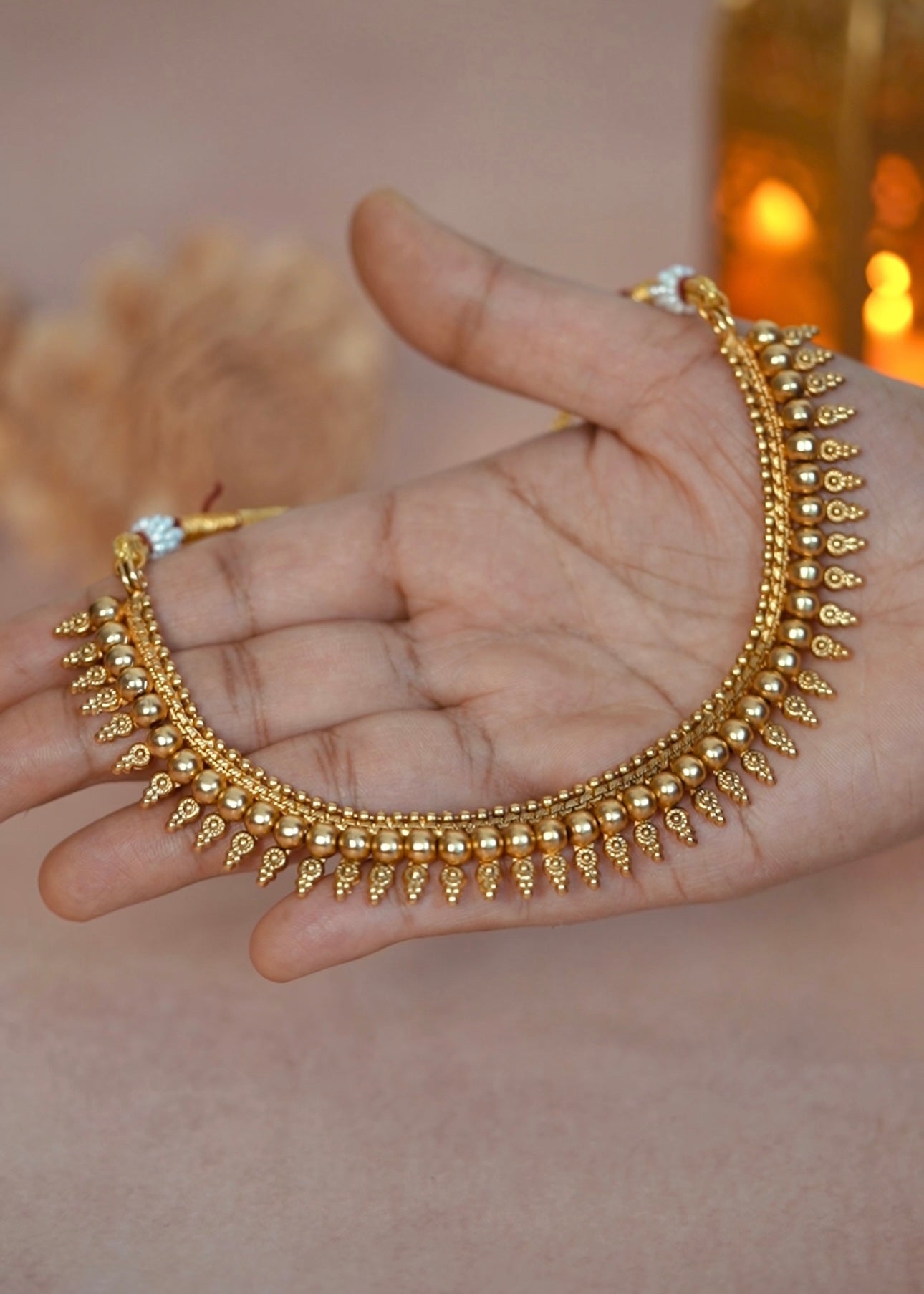 Golden necklace on a hand with a blurred background