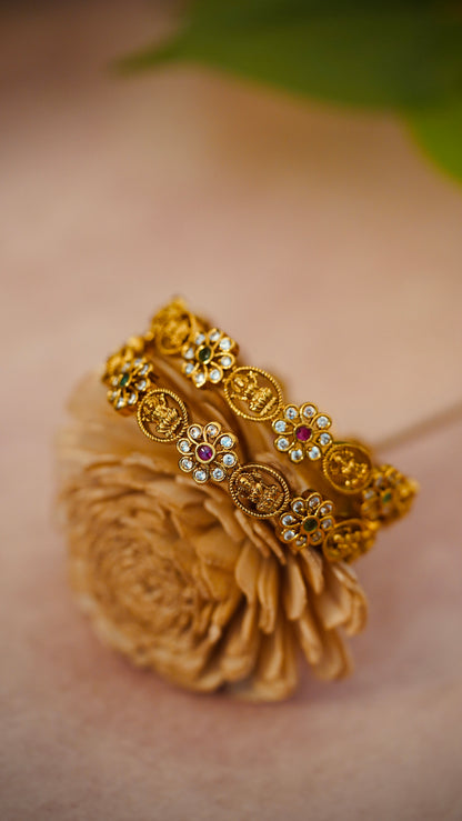 Floral Charm Bangles – Beautiful flower-shaped motifs with white stones and colored centers.