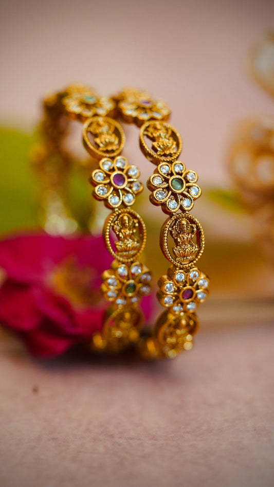 Floral Charm Bangles – Beautiful flower-shaped motifs with white stones and colored centers.