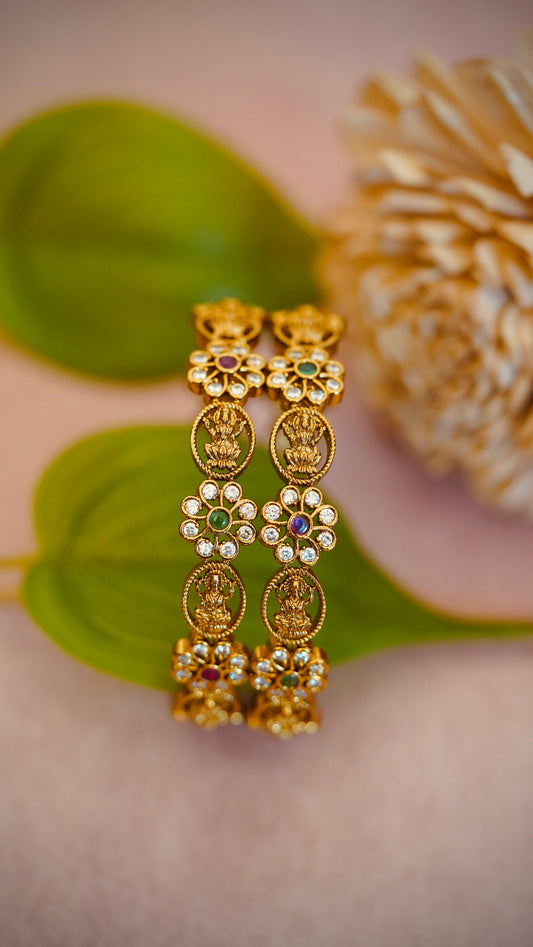 Floral Charm Bangles – Beautiful flower-shaped motifs with white stones and colored centers.