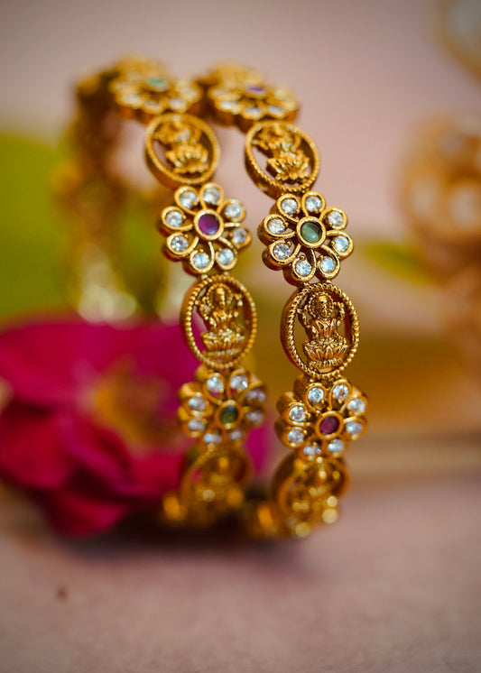 Floral Charm Bangles – Beautiful flower-shaped motifs with white stones and colored centers.